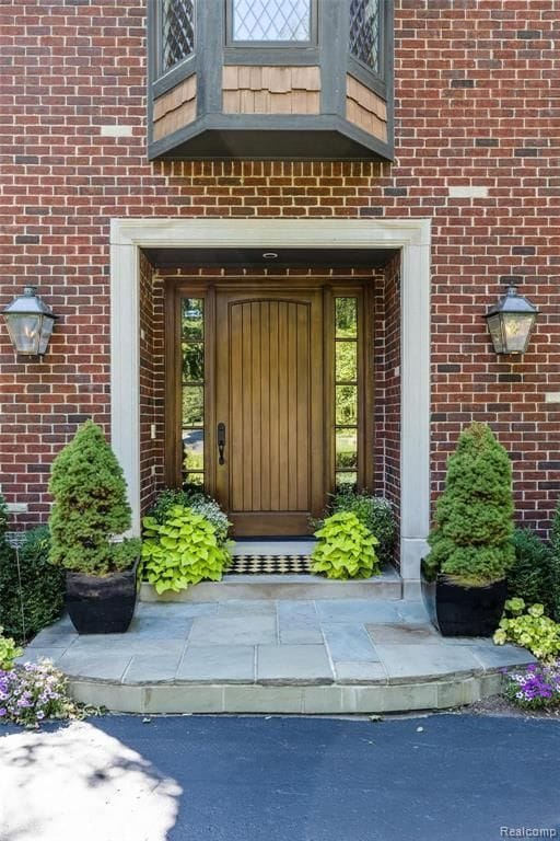 26061 Hawthorne Dr, Franklin, MI 48025 - view of exterior entry with brick siding and a balcony