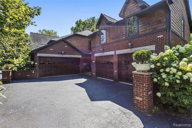 26061 Hawthorne Dr, Franklin, MI 48025 - view of home's exterior with brick siding, a garage, and driveway