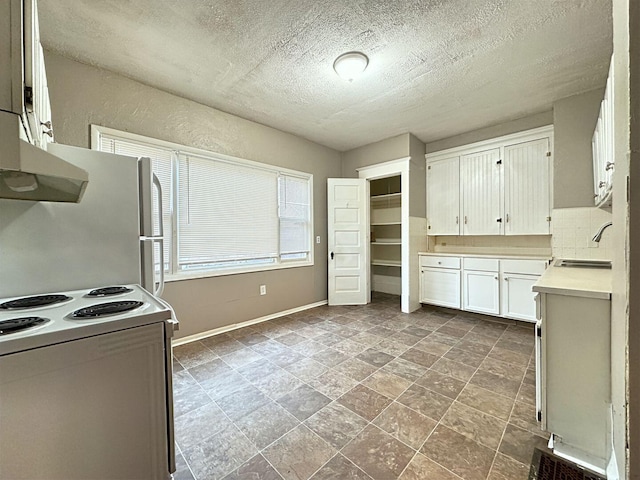 kitchen featuring white cabinetry, sink, range hood, a textured ceiling, and white appliances