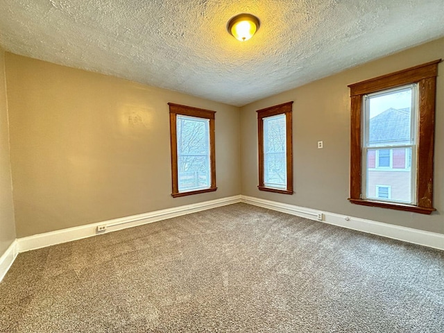 empty room with carpet and a textured ceiling