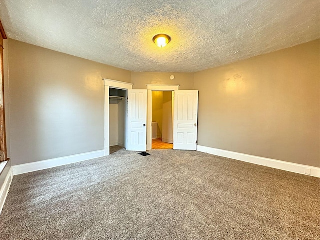 unfurnished bedroom with carpet flooring, a closet, and a textured ceiling