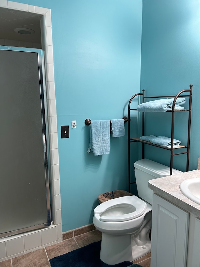 bathroom featuring tile patterned floors, vanity, toilet, and walk in shower