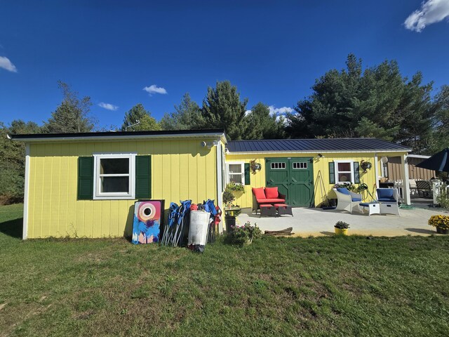 12259 Niemi, Kaleva, MI 49645 - back of house featuring a patio area, a lawn, and metal roof