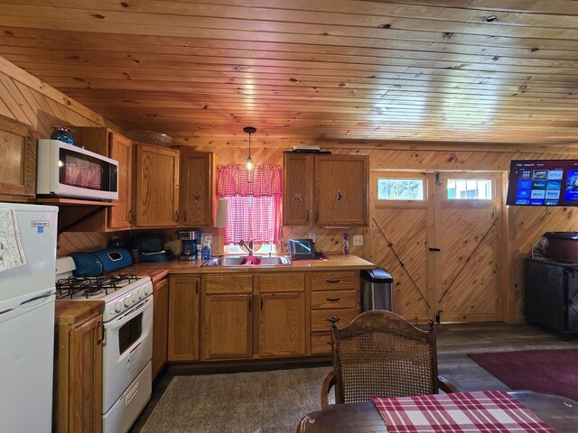 12259 Niemi, Kaleva, MI 49645 - kitchen with white appliances, a sink, brown cabinets, wood walls, and dark wood finished floors