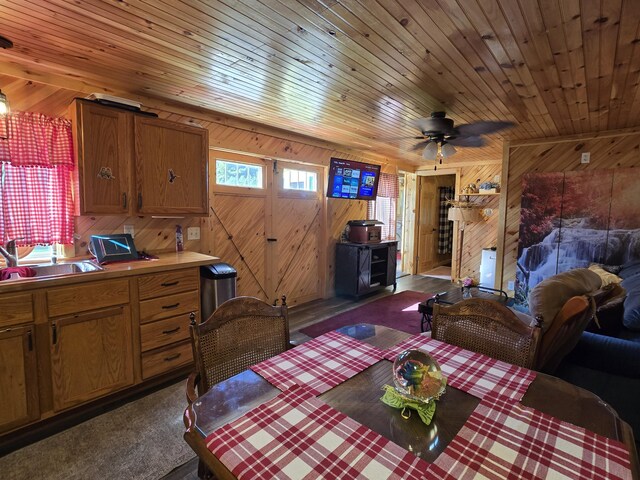 12259 Niemi, Kaleva, MI 49645 - dining area with wooden walls, a wood stove, wooden ceiling, dark carpet, and a ceiling fan
