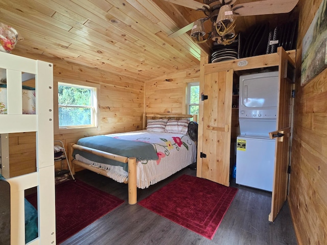 bedroom featuring vaulted ceiling, stacked washer / dryer, ceiling fan, and multiple windows