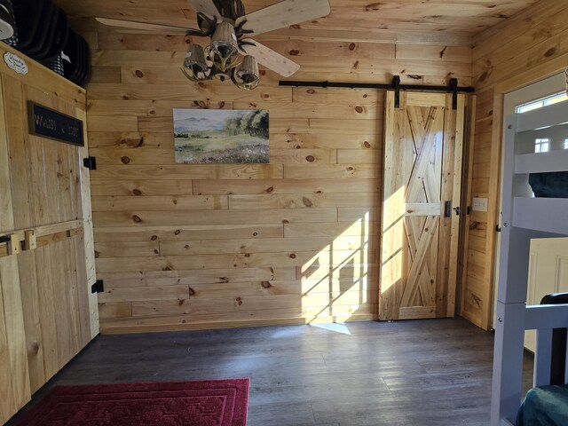 12259 Niemi, Kaleva, MI 49645 - entrance foyer with wooden walls, ceiling fan, a barn door, wood finished floors, and wooden ceiling