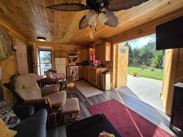 12259 Niemi, Kaleva, MI 49645 - living room with wood walls, wooden ceiling, wood finished floors, and a ceiling fan