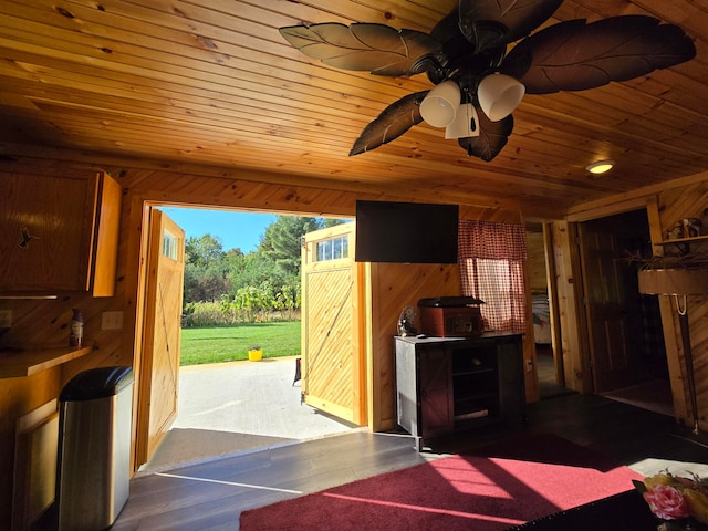 doorway to outside featuring wooden ceiling and wood walls