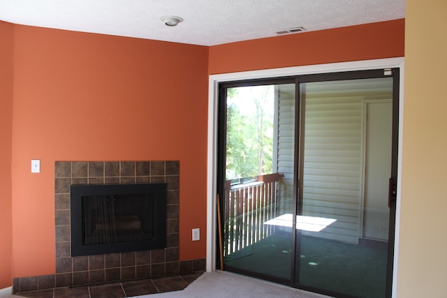 carpeted living room featuring a textured ceiling and a fireplace