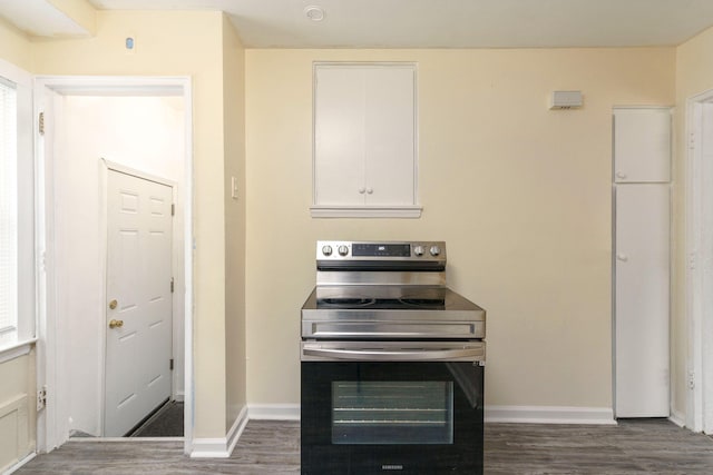 kitchen featuring white cabinets, stainless steel electric range, and dark wood-type flooring