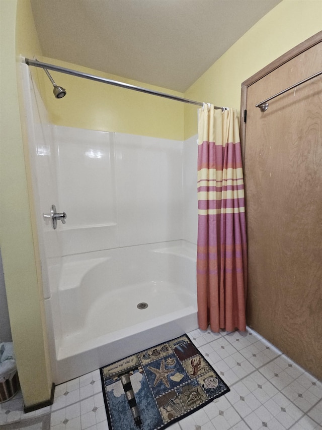 bathroom with a shower with shower curtain and tile patterned flooring