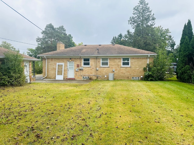 back of property with a patio, a yard, and central AC