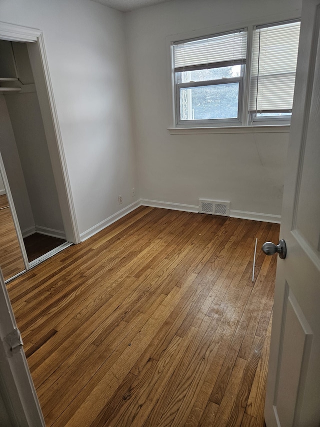 unfurnished bedroom featuring hardwood / wood-style flooring and a closet