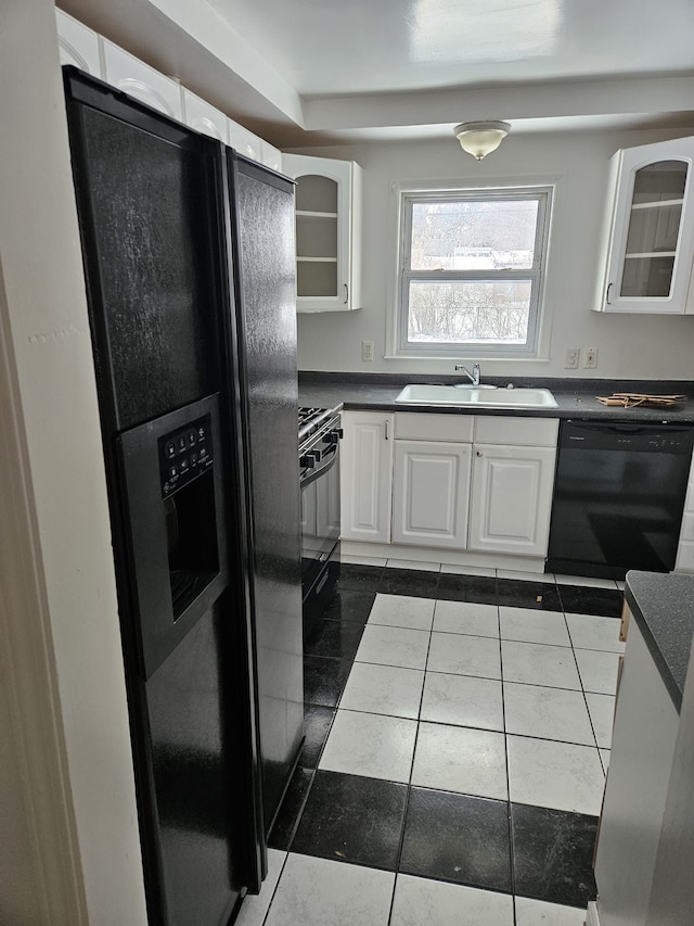 kitchen featuring sink, dark tile patterned floors, black appliances, and white cabinets