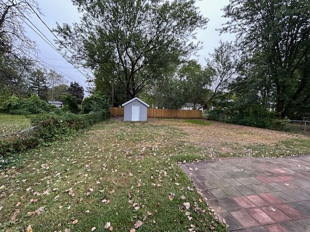 view of yard featuring a shed and a patio area