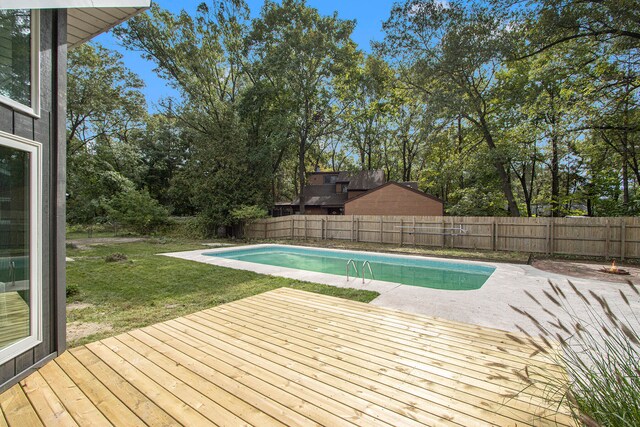 view of pool with a wooden deck and a yard