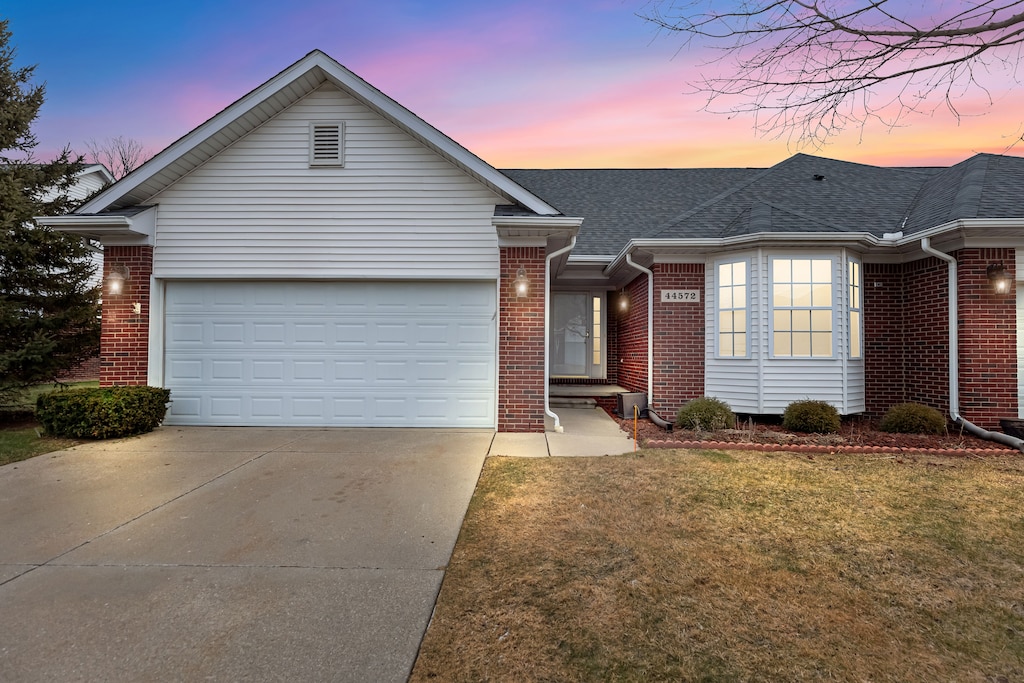 single story home featuring a yard and a garage