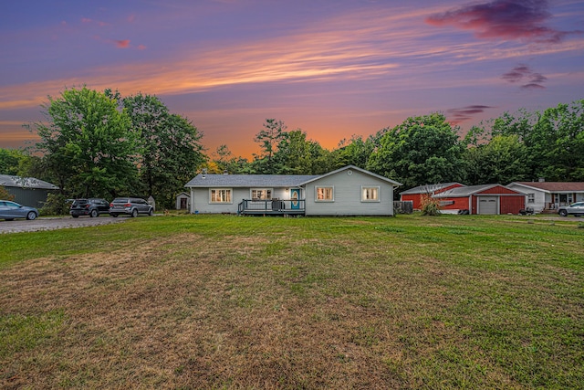 ranch-style house with a wooden deck and a lawn