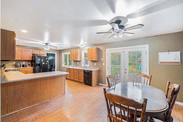 kitchen with sink, french doors, kitchen peninsula, black appliances, and light wood-type flooring