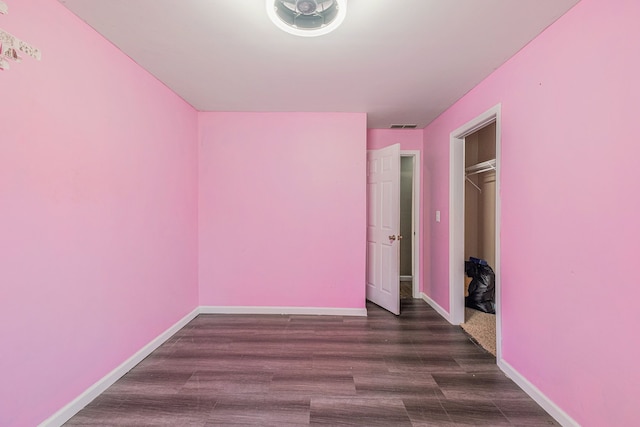 unfurnished bedroom with dark hardwood / wood-style floors and a closet