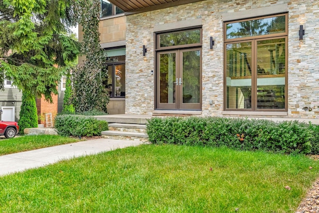 entrance to property with a yard and french doors