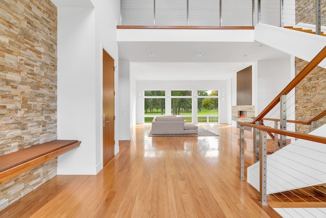 entrance foyer featuring a towering ceiling and light wood-type flooring