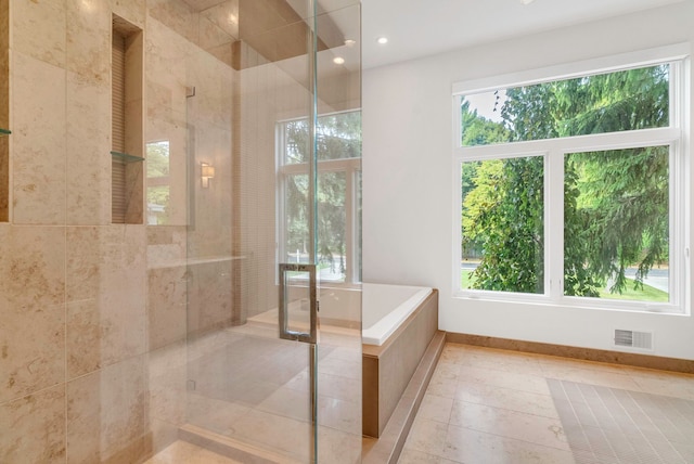 bathroom featuring tile patterned flooring, separate shower and tub, and a wealth of natural light