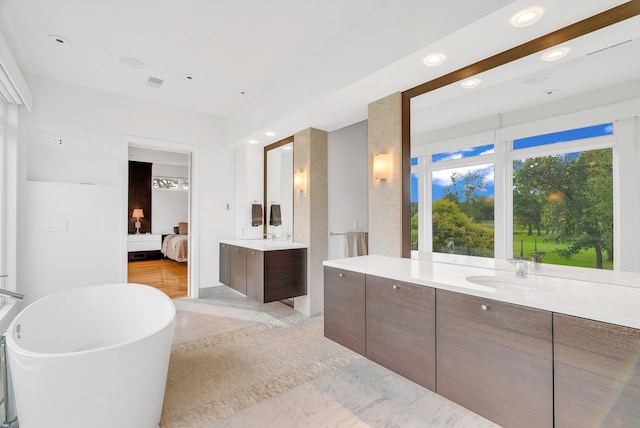 bathroom featuring vanity, wood-type flooring, and a tub to relax in