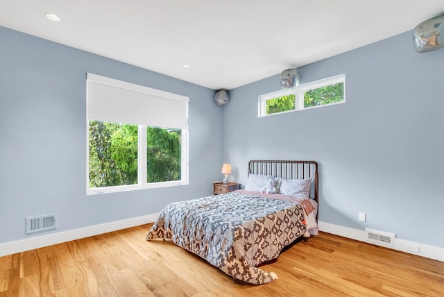 bedroom featuring wood-type flooring and multiple windows