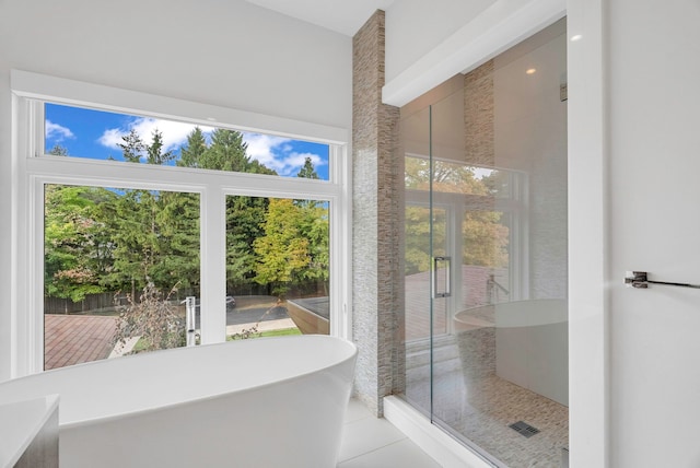 bathroom featuring tile patterned flooring, plenty of natural light, and plus walk in shower