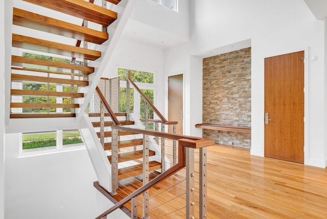 stairs with a high ceiling, hardwood / wood-style flooring, and a wealth of natural light