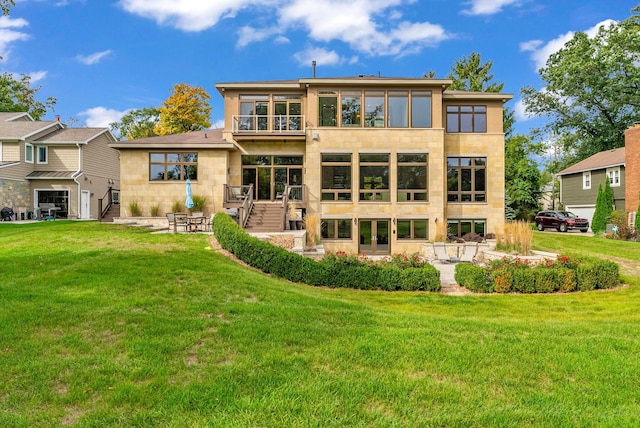 back of house featuring a balcony and a lawn