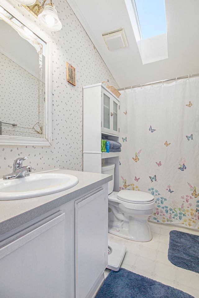 bathroom with vanity, a skylight, toilet, and ornamental molding