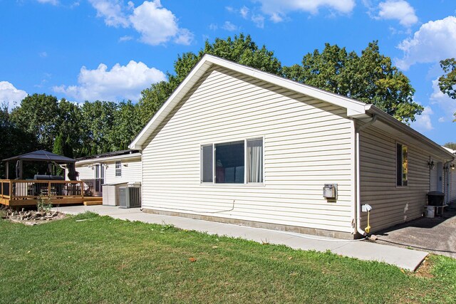 view of side of property featuring a gazebo, cooling unit, a lawn, and a wooden deck