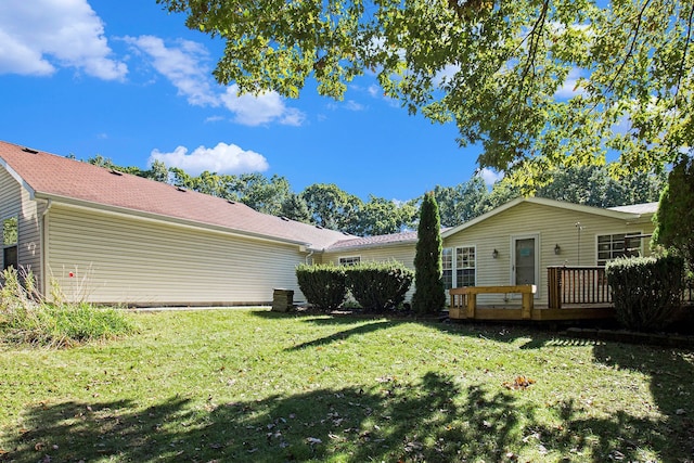 back of house with a deck and a yard