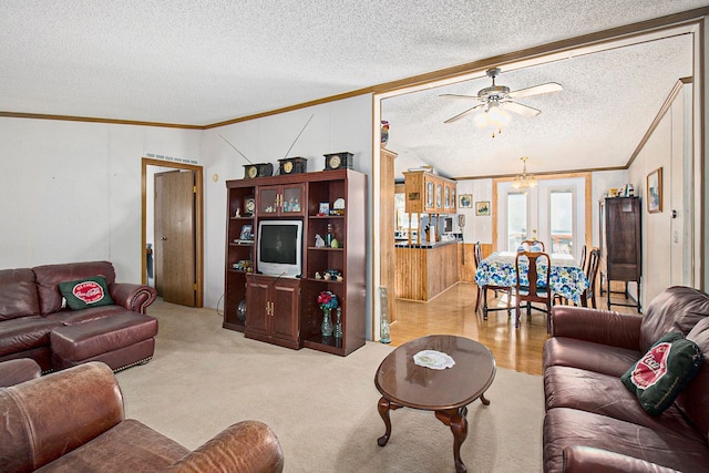 living room with a textured ceiling, light colored carpet, vaulted ceiling, ceiling fan, and crown molding