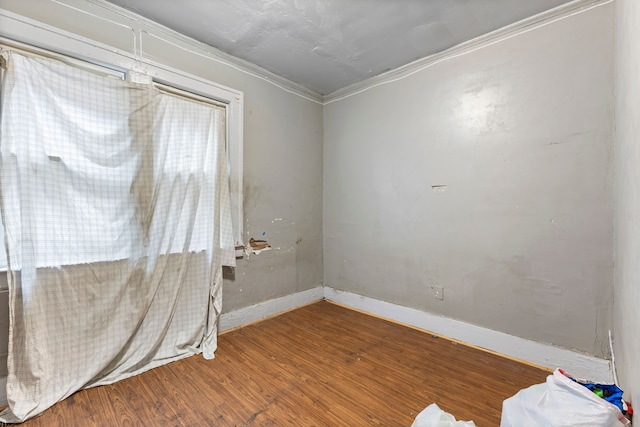 unfurnished room with hardwood / wood-style floors and crown molding