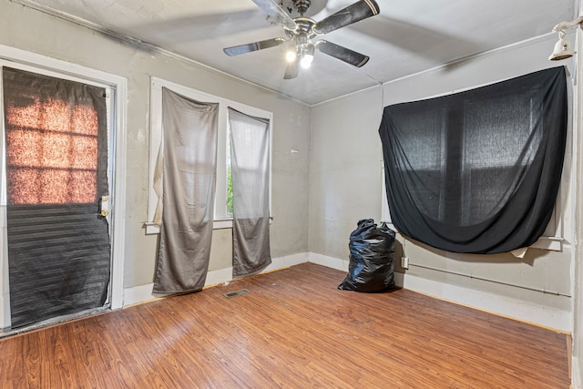 interior space with wood-type flooring, ceiling fan, and crown molding