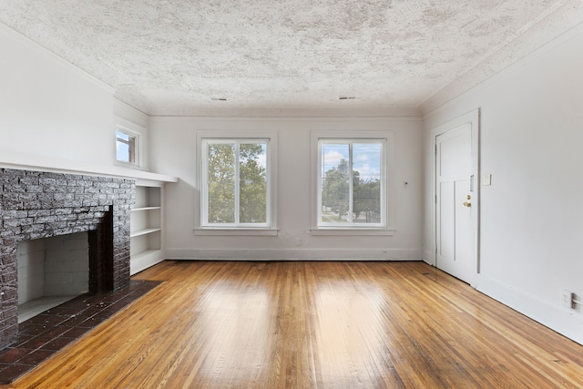 unfurnished living room with a textured ceiling, built in features, dark hardwood / wood-style floors, and ornamental molding