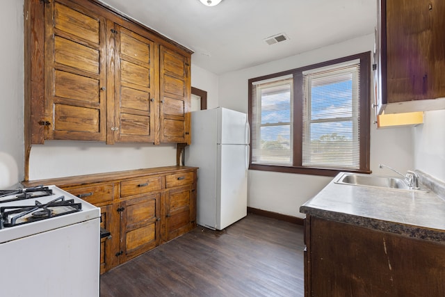 kitchen with dark hardwood / wood-style flooring, white appliances, and sink