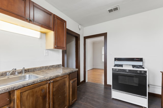 kitchen with white range with gas cooktop, sink, and dark hardwood / wood-style floors