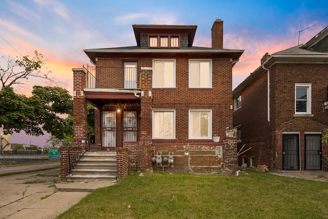 view of front of home featuring a lawn and a balcony