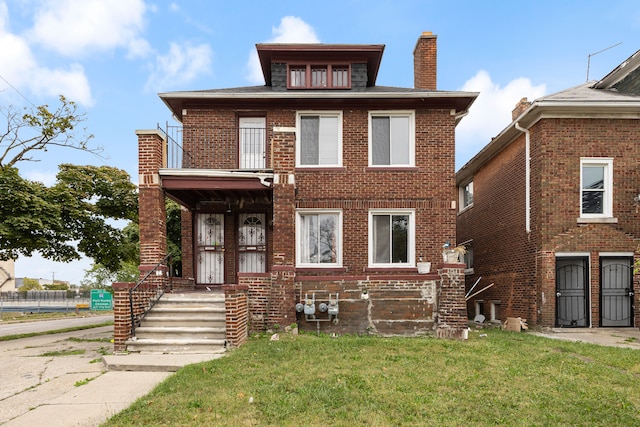 view of front facade featuring a balcony and a front lawn