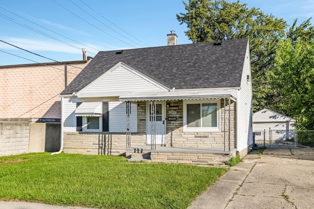 bungalow with a front yard, an outbuilding, and a garage