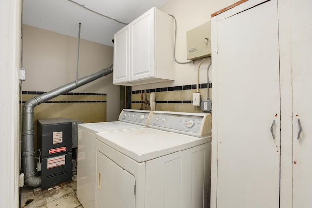 laundry area with washer and clothes dryer and cabinets