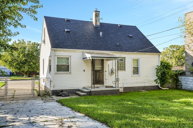 rear view of property featuring a lawn