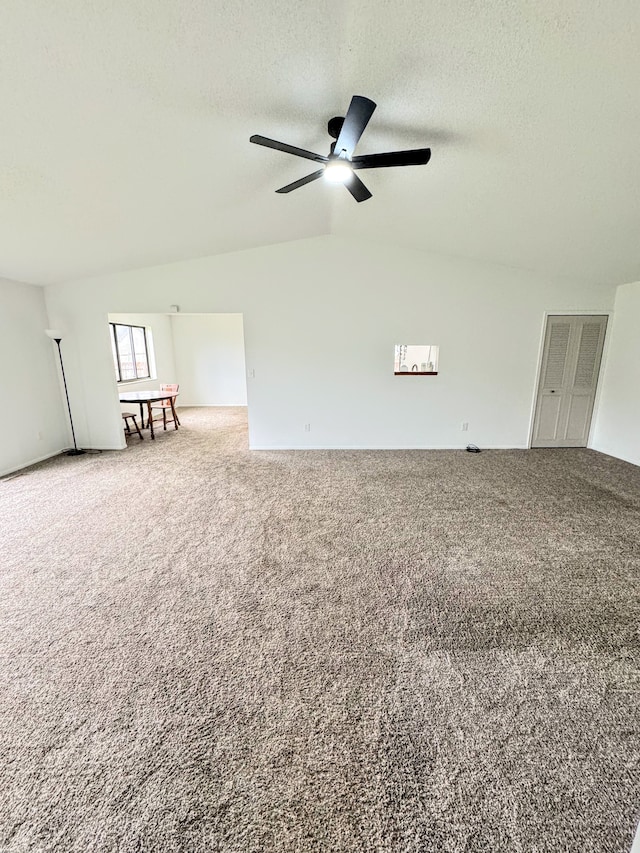 carpeted empty room featuring a textured ceiling, ceiling fan, and lofted ceiling