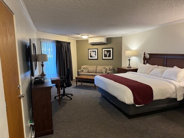 bedroom featuring a textured ceiling, dark carpet, a wall mounted AC, and crown molding