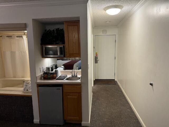 interior space featuring a textured ceiling, crown molding, and sink